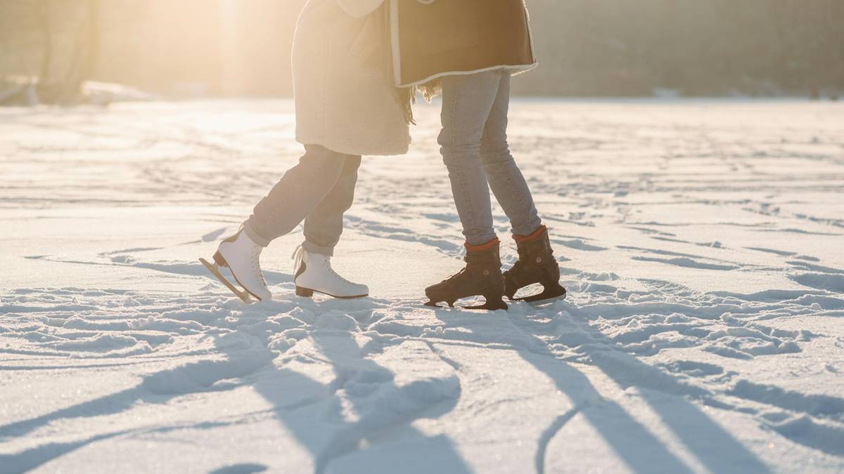 Dwie osoby na łyżwach na śniegu w słoneczny dzień.