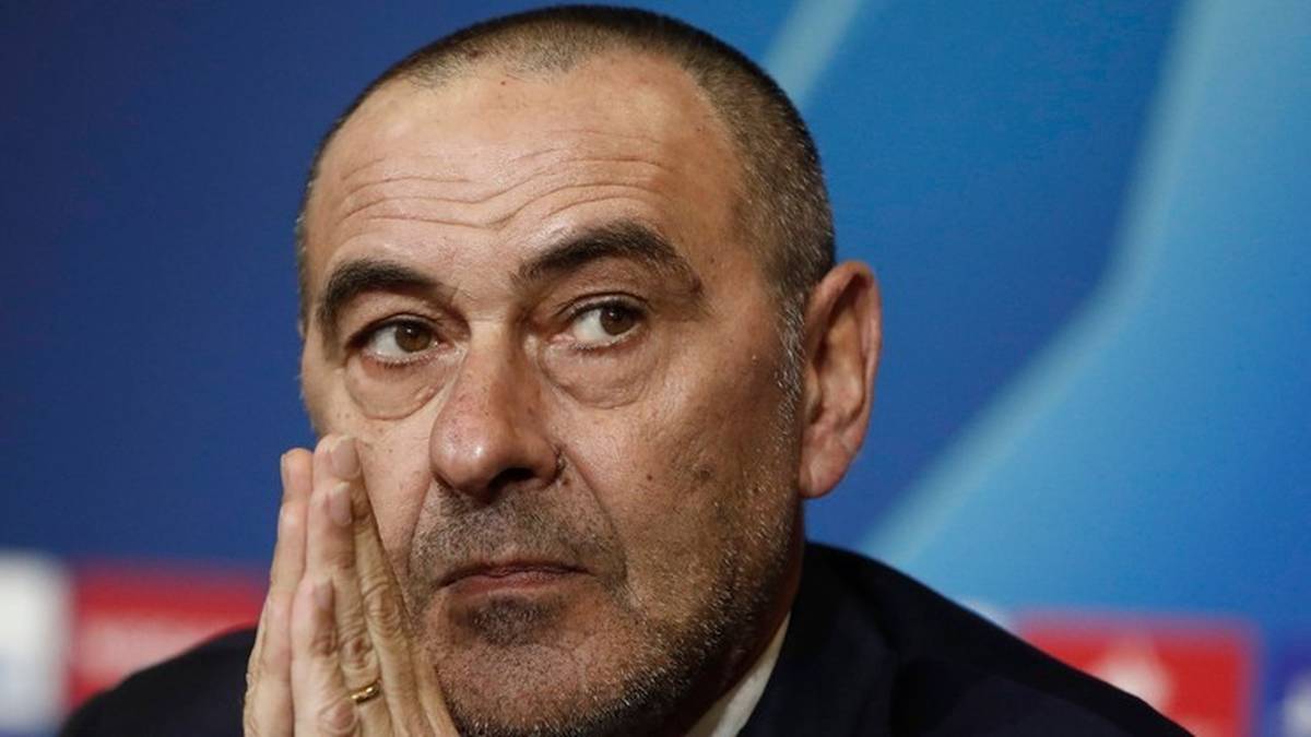 Portret dojrzałego mężczyzny z widocznymi zmarszczkami, o kr&oacute;tkich, siwiejących włosach, patrzącego lekko w bok. Jego dłoń znajduje się przy policzku, podparta na kciuku.