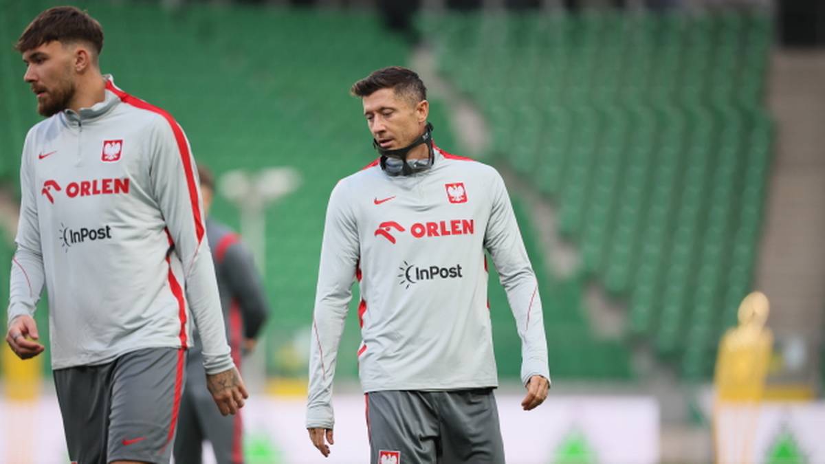 Dw&oacute;ch piłkarzy w strojach treningowych reprezentacji Polski, Robert Lewandowski w środku kadru, obok niego inny zawodnik.