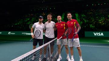 Czterech tenisistów pozuje do zdjęcia na korcie tenisowym.