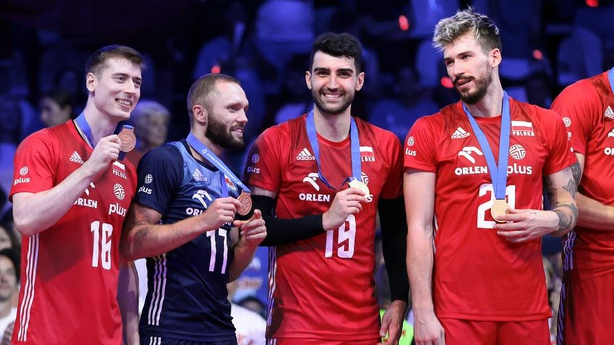 Czterech mężczyzn w strojach sportowych z medalami na szyjach.