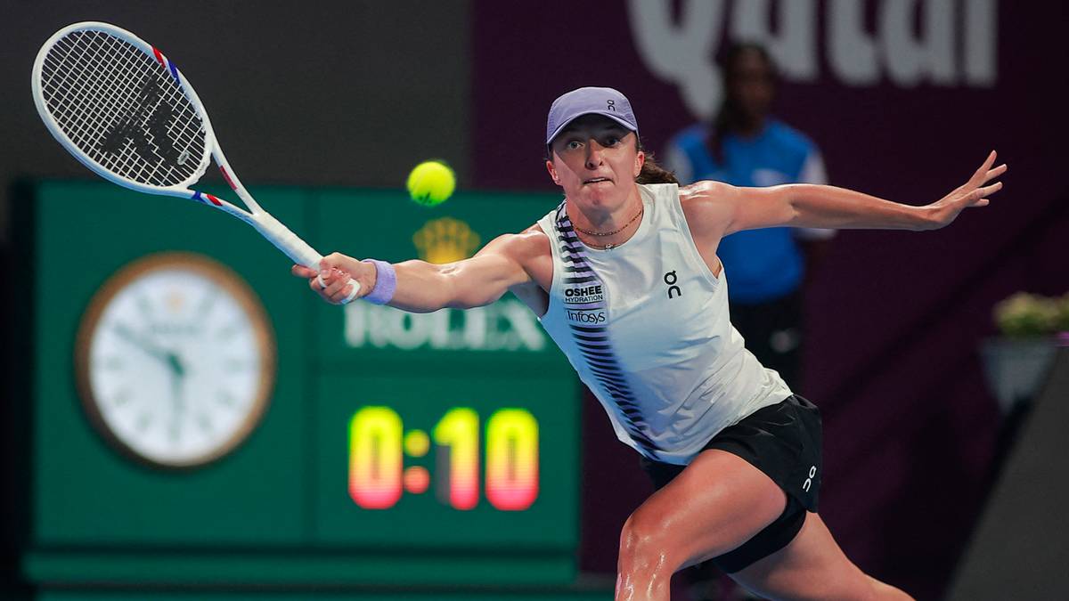 Tenisistka Iga Świątek wykonuje forhend podczas meczu na korcie tenisowym.