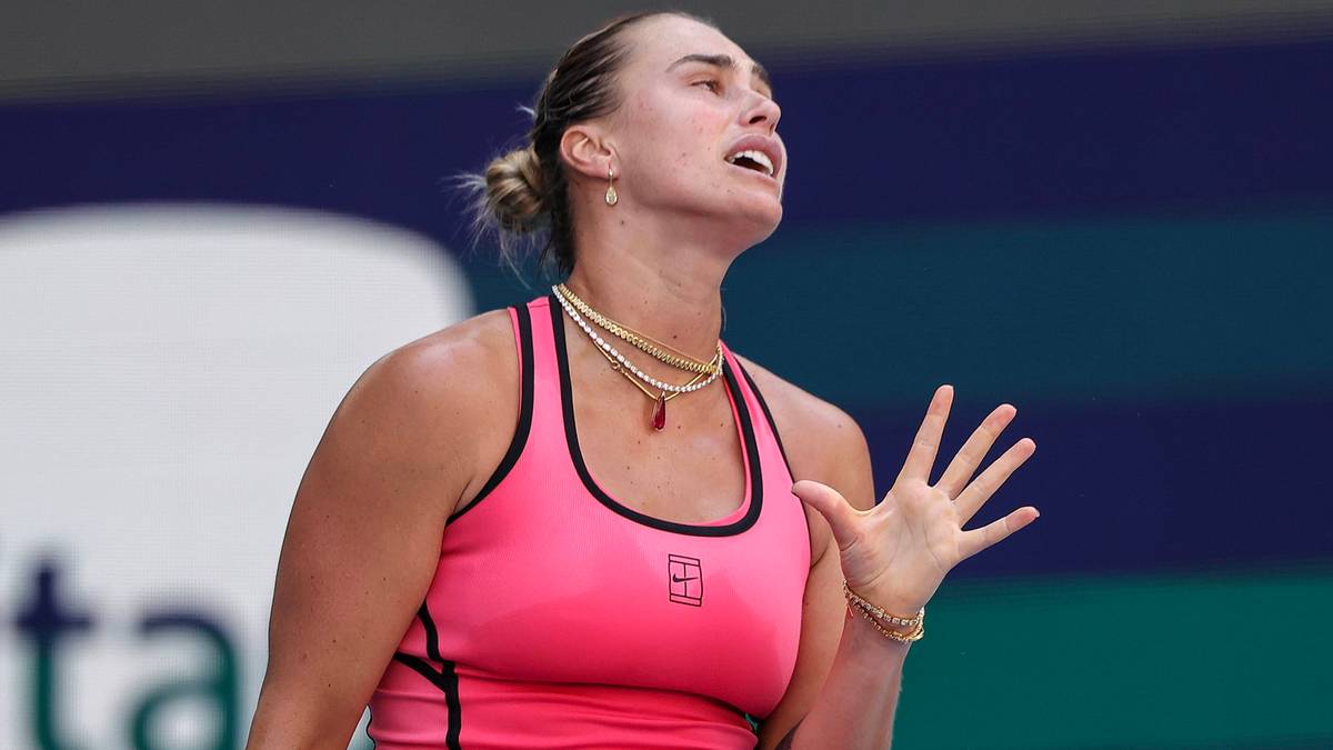Tenisistka Aryna Sabalenka w r&oacute;żowej sukience sportowej trzyma rakietę tenisową.