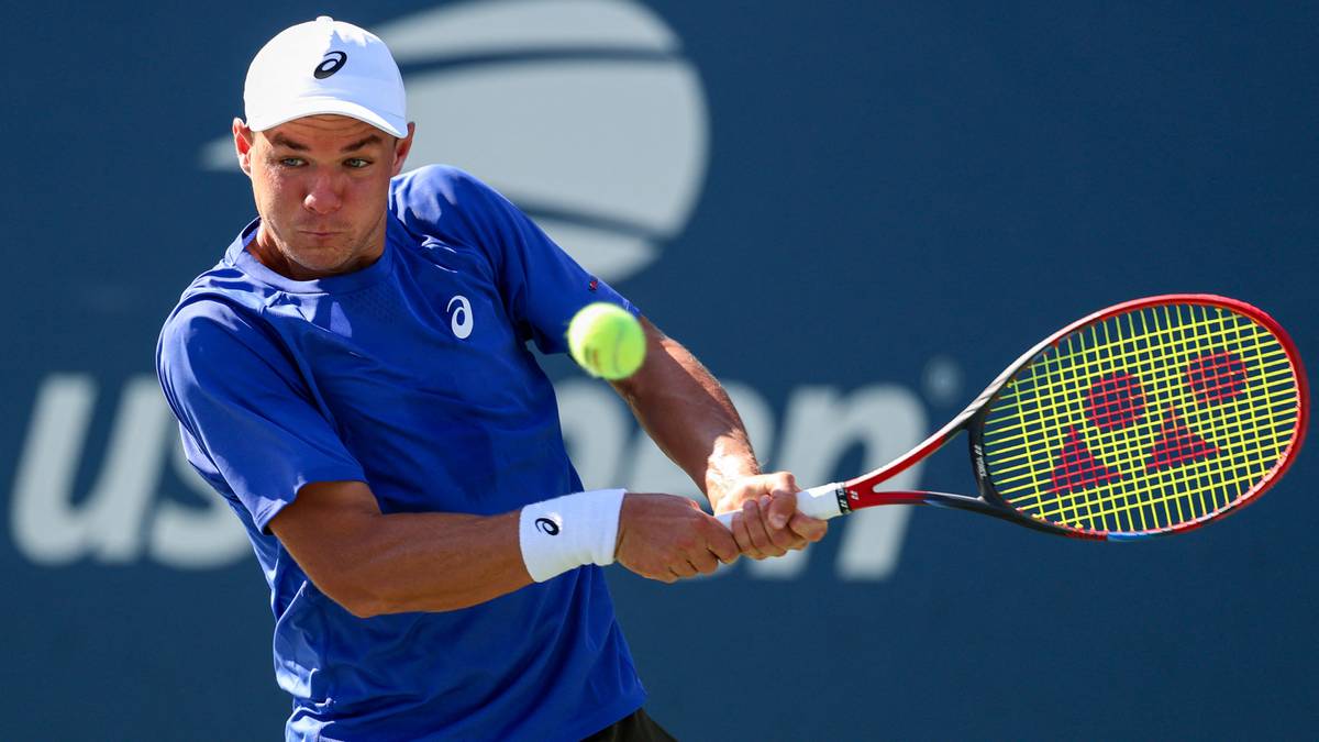 Tenisista Kamil Majchrzak podczas meczu uderza piłkę rakietą.