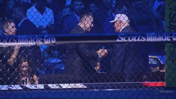 Donald Trump i Dana White ściskają sobie dłonie na tle klatki ringowej podczas gali UFC Freedom 250.