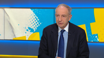 Władysław Teofil Bartoszewski w garniturze i krawacie udziela wywiadu.