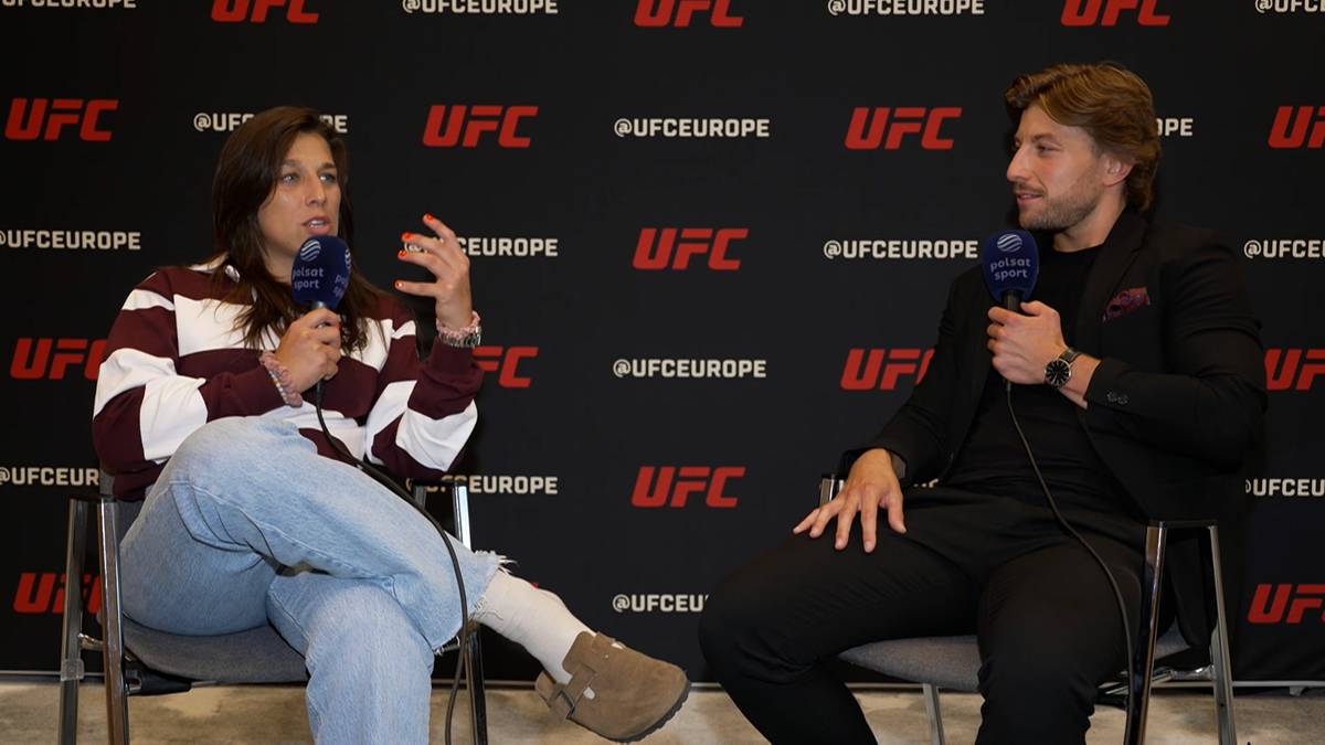 Kobieta i mężczyzna siedzą i rozmawiają z mikrofonami na tle logo UFC.