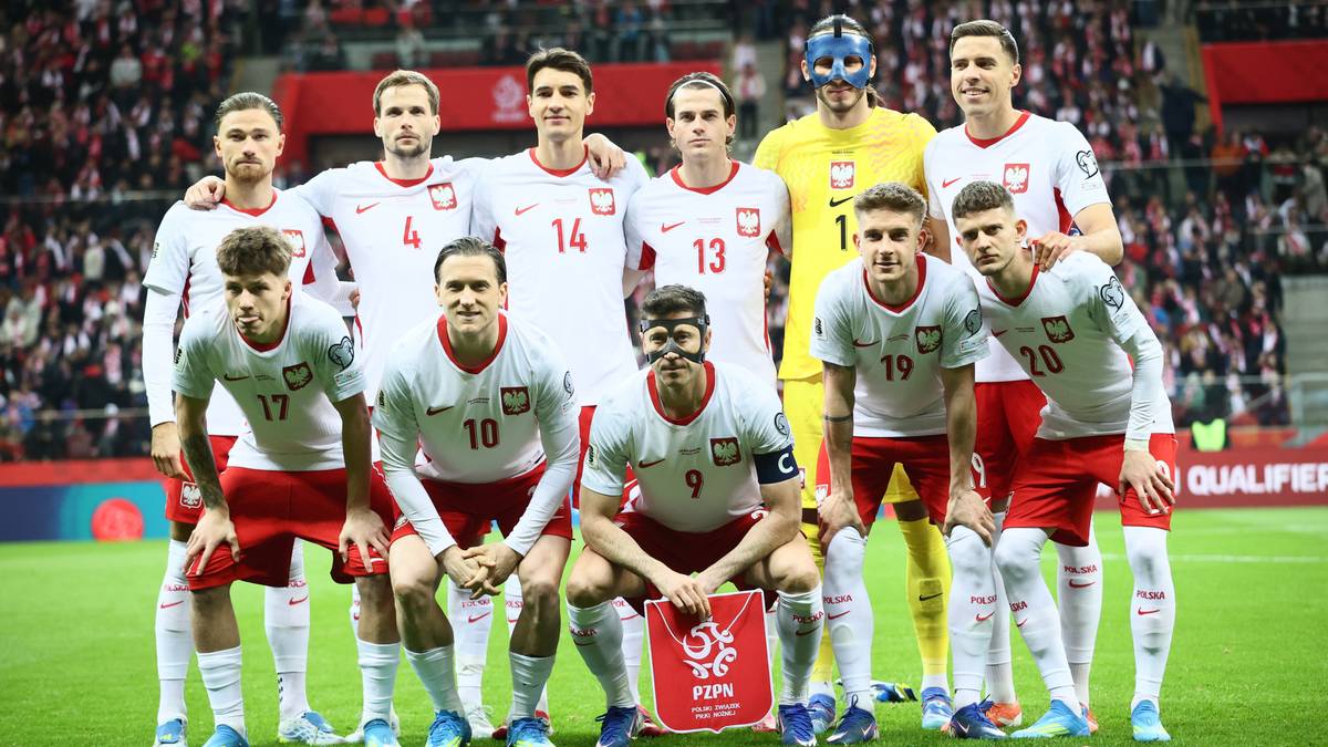 Drużyna piłkarska Polski w strojach meczowych na boisku.