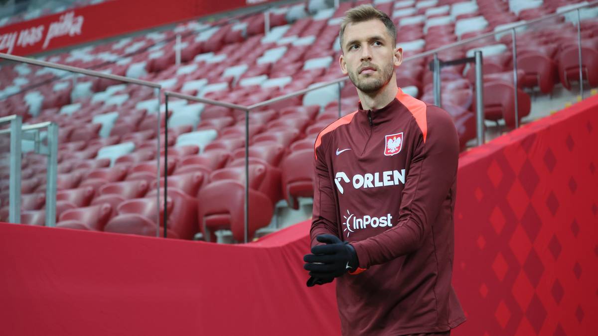 Piłkarz reprezentacji Polski Paweł Bochniewicz w stroju meczowym na tle trybun stadionu.