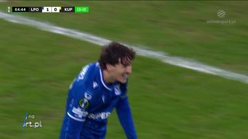 Piłkarz Lecha Poznań w niebieskiej koszulce z numerem 10 celebruje zdobycie bramki. Na ekranie widoczny wynik meczu 1:0 dla LPO.