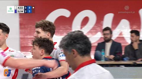 Dwóch młodych siatkarzy ZAKSA Kędzierzyn-Koźle świętuje zdobyty punkt, jeden z nich jest przytulany przez kolegę. W tle widoczny wynik meczu i logotypy sponsorów.