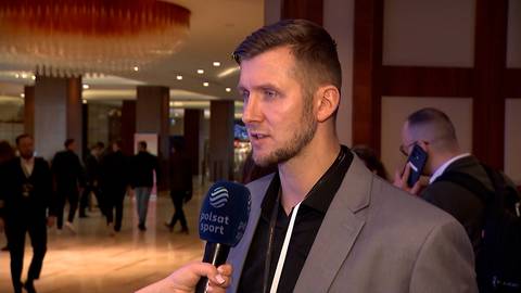 Przemysław Zamojski, sportowiec, udziela wywiadu do mikrofonu Polsat Sport. W tle widać innych ludzi.