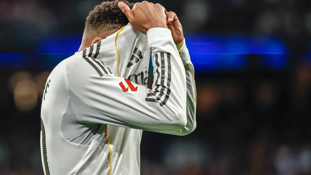 Piłkarz zakrywa twarz koszulką.