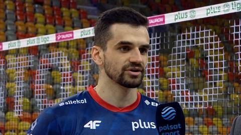 Portret Jakuba Szymańskiego, siatkarza w niebieskiej koszulce sportowej, podczas wywiadu.