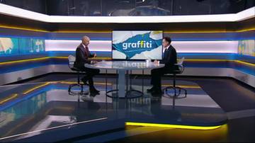 Dw&oacute;ch mężczyzn siedzi przy okrągłym stole w studiu telewizyjnym. Na ekranie za nimi widnieje napis "graffiti".