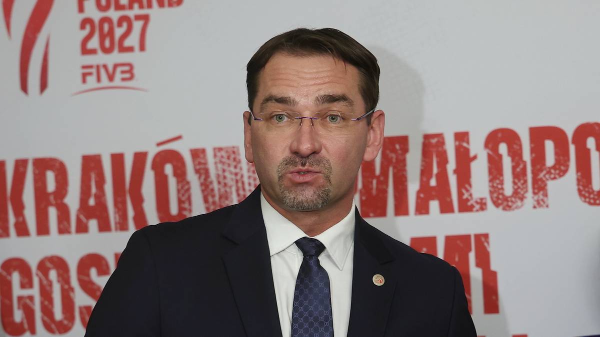 Trzy osoby stojące przed ścianą z logo Mistrzostw Świata w siatkówce mężczyzn 2027. Mężczyzna w garniturze przemawia do mikrofonu.