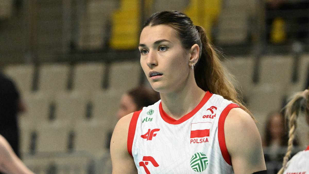 Siatkarka w białej koszulce z czerwonymi elementami i logotypami, z biało-czerwoną flagą Polski na piersi.