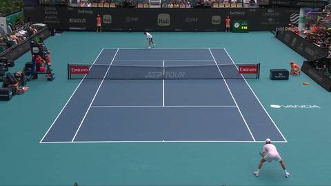 Dw&oacute;ch tenisist&oacute;w gra na korcie tenisowym o niebieskiej nawierzchni.