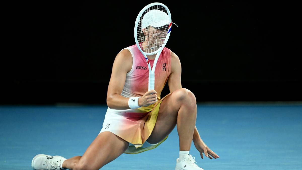 Tenisistka w akcji na korcie, trzymająca rakietę przed twarzą, w pozie dynamicznego uderzenia.