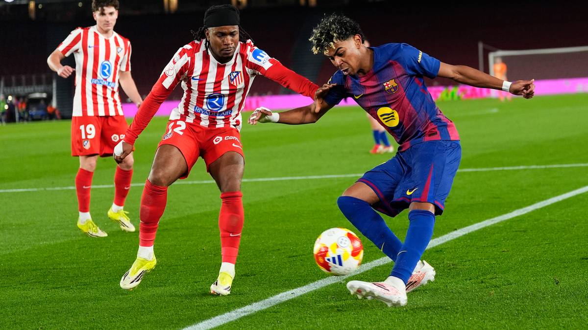 Dw&oacute;ch piłkarzy walczy o piłkę na boisku, jeden w stroju Barcelony, drugi w stroju przeciwnika.