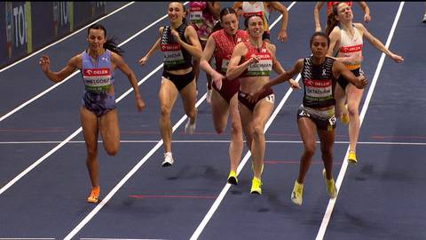 Anna Wielgosz wcolored stroju sportowym biegnie w zawodach lekkoatletycznych, zajmując drugie miejsce.