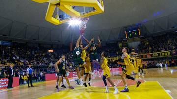 Gracze drużyn Aris Saloniki i Betsson WKS Śląsk Wrocław rywalizują o piłkę pod koszem podczas meczu koszykówki.