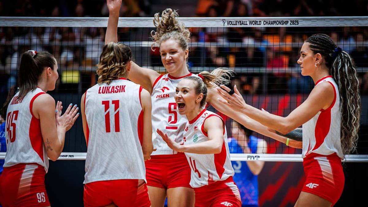 Polskie siatkarki w białych strojach z czerwonymi detalami, świętujące zwycięstwo na boisku podczas meczu.
