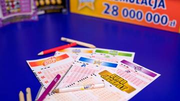 Kupony gier losowych Lotto i Eurojackpot na niebieskim tle, z widocznymi kredkami i informacją o kumulacji 28 000 000 zł.