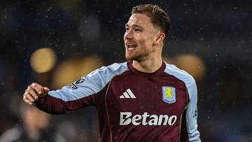 Piłkarz w bordowo-jasnoniebieskiej koszulce z logo Betano i herbem klubu.