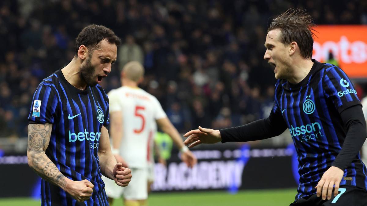 Dw&oacute;ch piłkarzy Interu Mediolan świętuje na boisku piłkarskim.