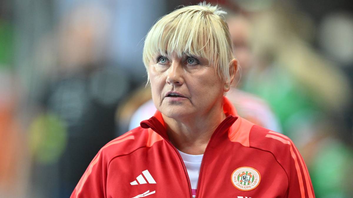 Portret kobiety w czerwonej kurtce sportowej z blond włosami, patrzącej w bok.