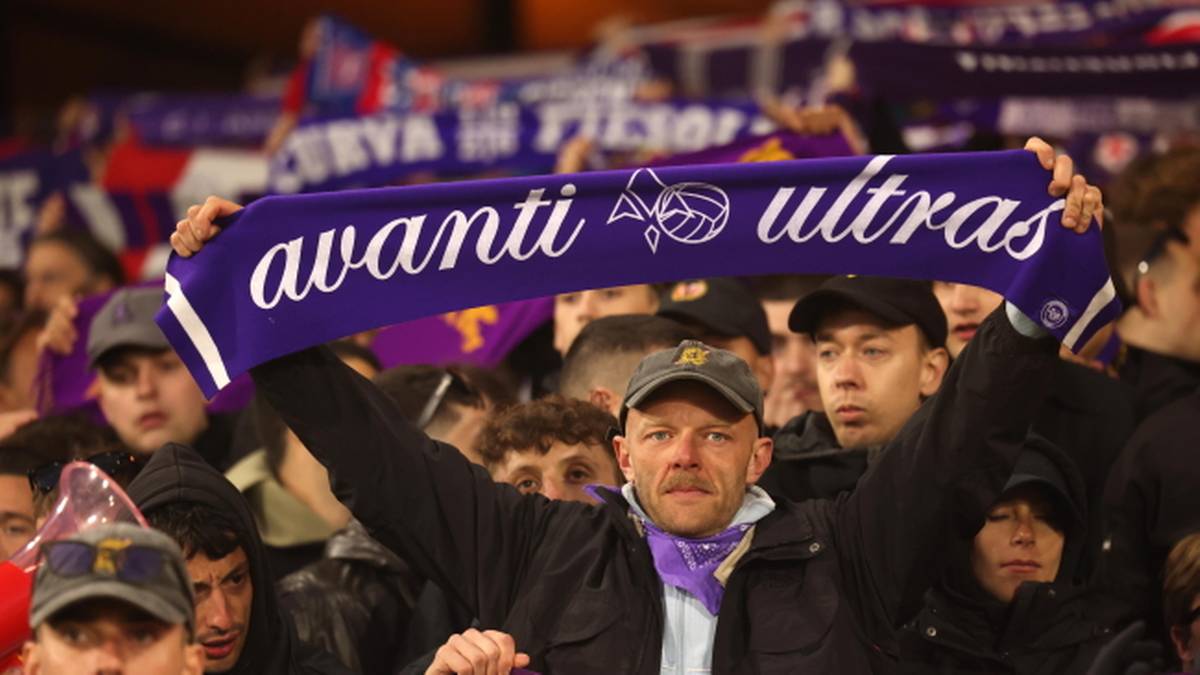 Kibice na meczu piłkarskim, jeden z nich trzyma transparent z napisem "avanti ultras".