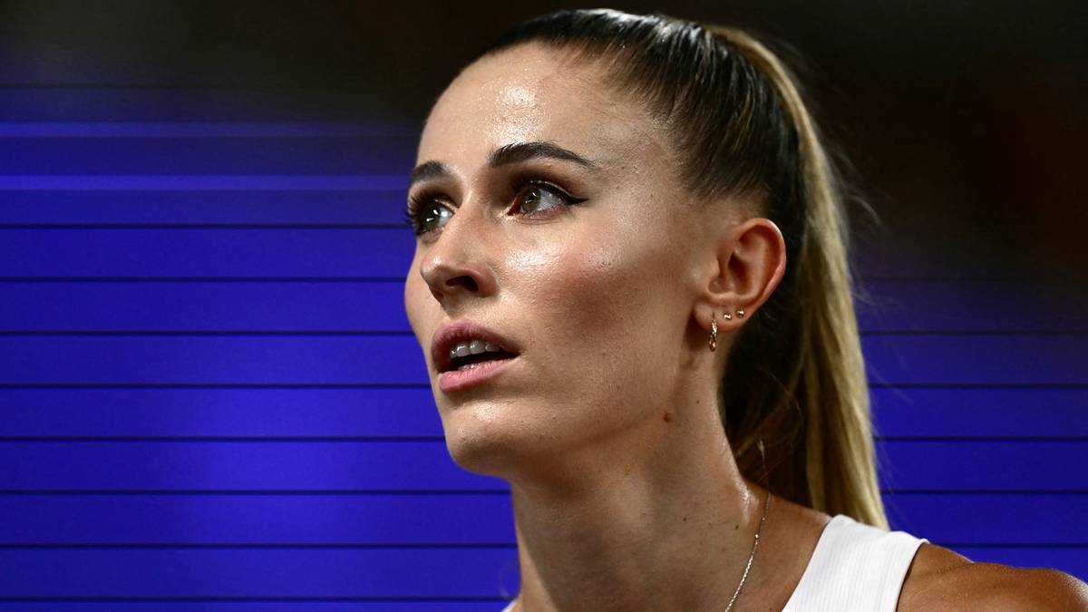 Portret kobiety z blond kucykiem, w białej koszulce sportowej, patrzącej w bok z determinacją na twarzy.