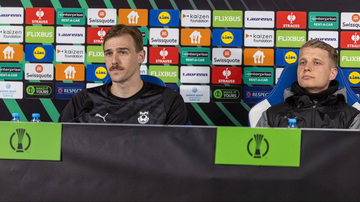 Dwóch mężczyzn siedzi za stołem podczas konferencji prasowej, na tle ścianki z logotypami Ligi Konferencji Europy.