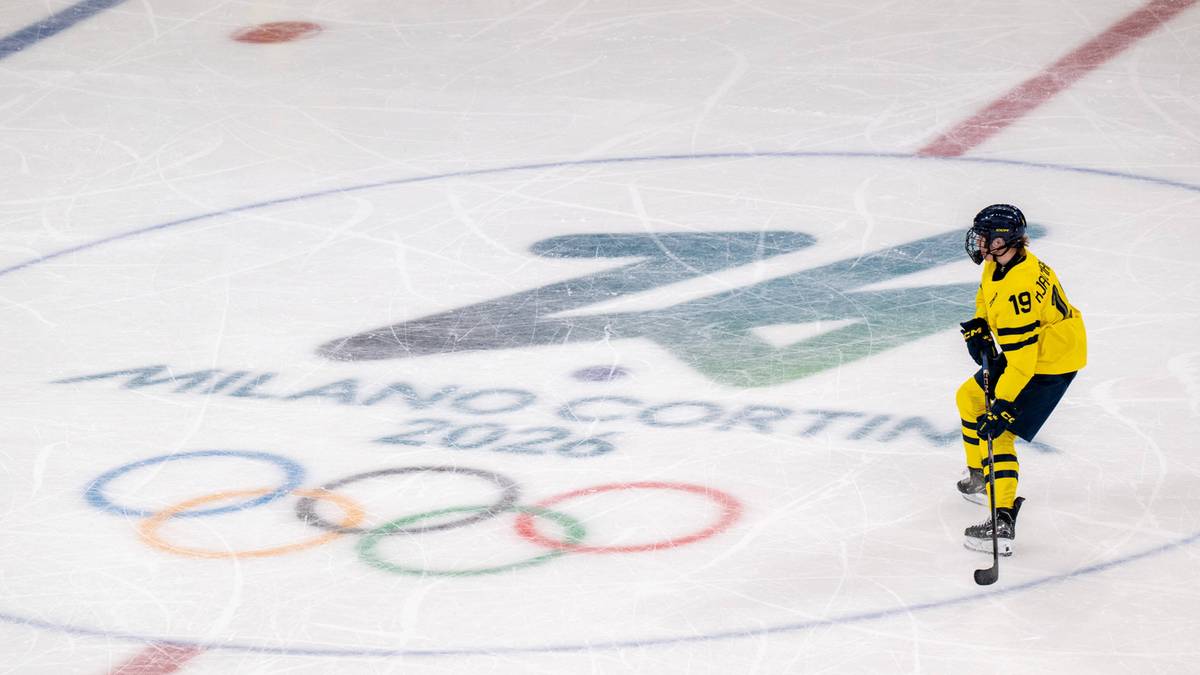Hokeistka w ż&oacute;łtym stroju narciarskim z numerem 19 stoi na lodowisku obok logo "Milano Cortina 2026" i k&oacute;ł olimpijskich.