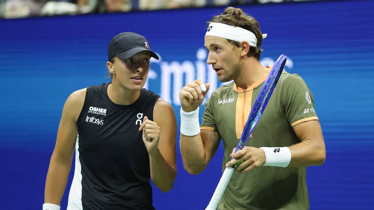 Iga Świątek i Casper Ruud stoją obok siebie na korcie tenisowym, patrząc w kierunku rozm&oacute;wcy.