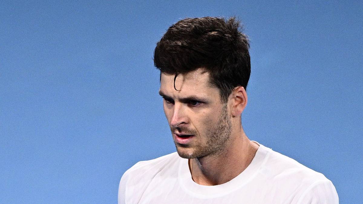 Tenisista świętujący punkt na korcie tenisowym, trzymający rakietę.