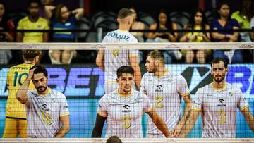 Siatkarze Aluronu CMC Warta Zawiercie w białych koszulkach stoją przy siatce.