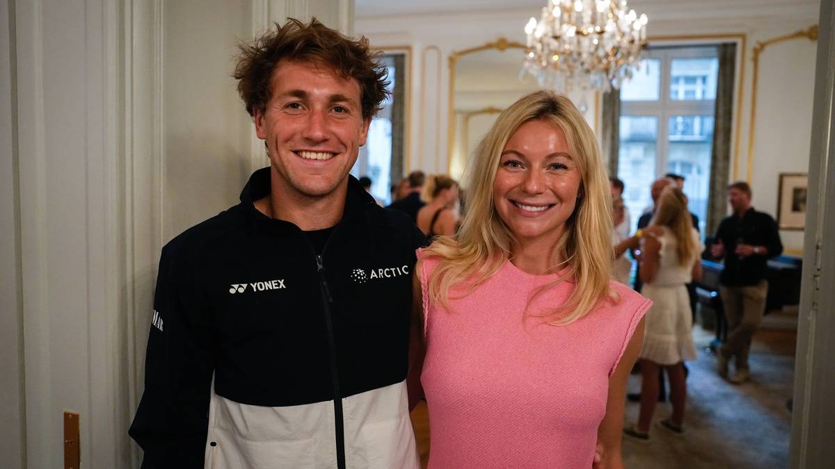 Casper Ruud i jego partnerka uśmiechają się do zdjęcia.