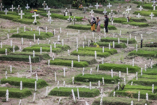 Na zdjęciu: krewni odwiedzający grób bliskiego na cmentarzu, na którym grzebane sa ofiary COVID-19 w Medanie w Północnej Sumatrze (Indonezja). W kraju potwierdzono do tej pory 287 tys. przypadków koronawirusa.