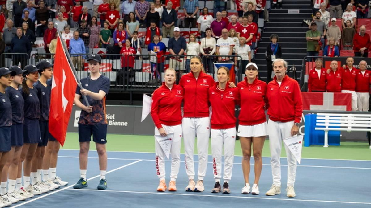 Drużyna tenisowa z flagą, gotowa do rozgrywek w Billie Jean King Cup.