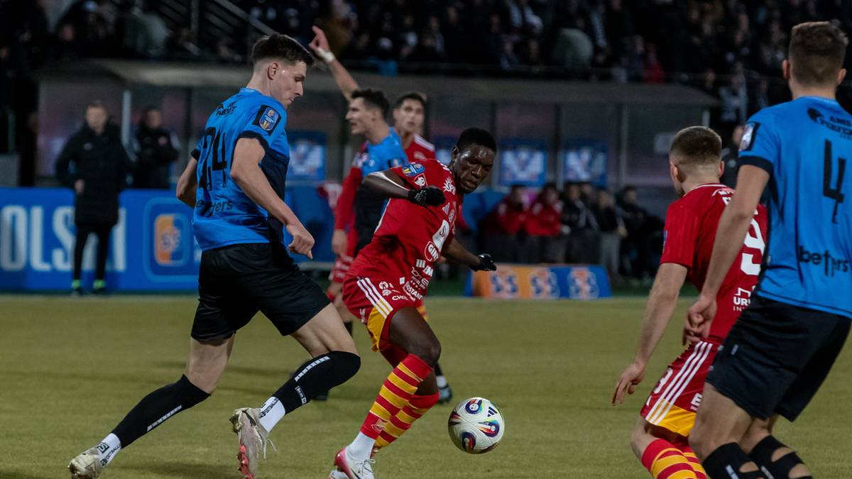 Piłkarze walczą o piłkę na boisku podczas meczu piłki nożnej.