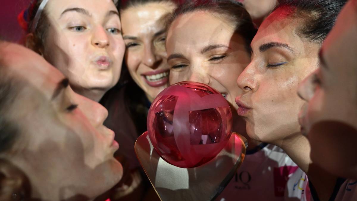 Grupa siatkarek PGE Budowlanych Łódź świętuje z pucharem, kilka z nich całuje trofeum.