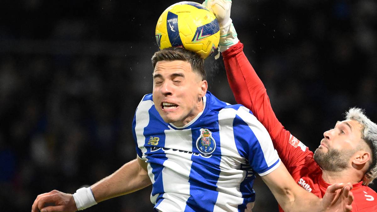 Dwóch piłkarzy walczy o piłkę w powietrzu, jeden w koszulce FC Porto, drugi w stroju bramkarskim.
