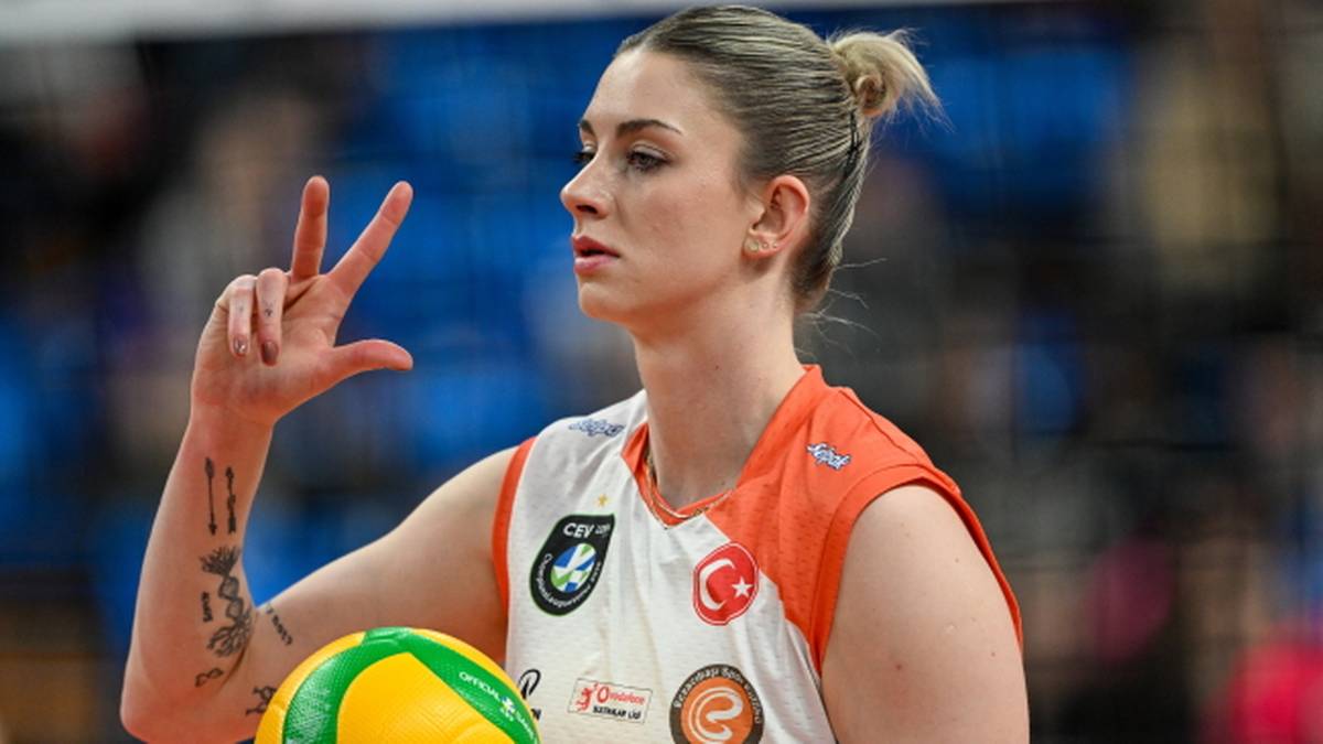 Siatkarka Magdalena Stysiak z piłką siatkową, pokazująca dwa palce