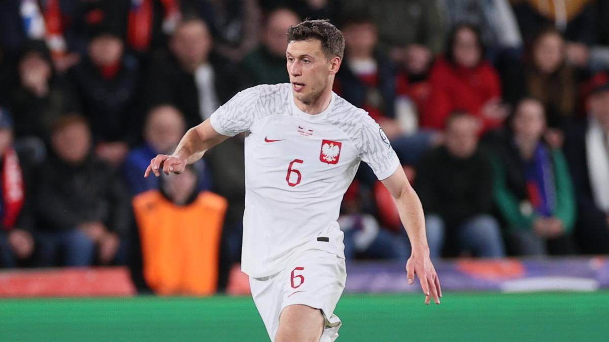 Krystian Bielik, zawodnik reprezentacji Polski w piłce nożnej, w białej koszulce z numerem 6, biegnie po boisku.