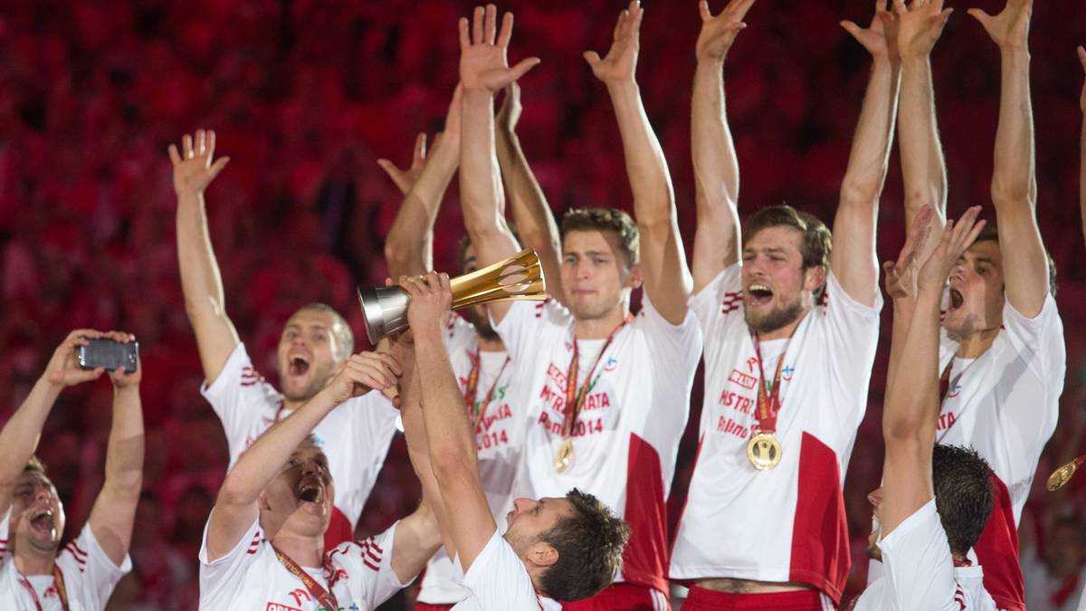 Siatkarze reprezentacji Polski świętują zwycięstwo, unosząc ręce w górę i ściskając puchar.