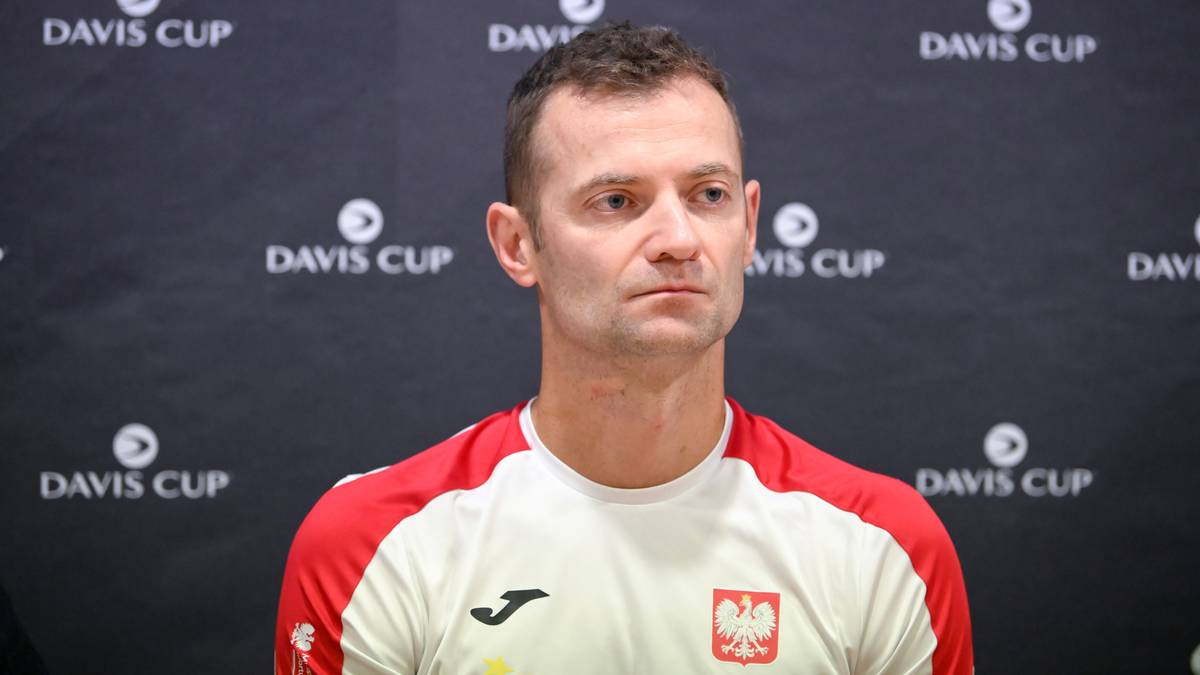Mężczyzna w białej koszulce z czerwonymi rękawami, na której widnieje godło Polski.