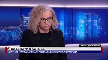 Kobieta siedząca w studio telewizyjnym, z widokiem na nocne miasto w tle. Na ekranie widnieje jej imię i nazwisko oraz stanowisko.