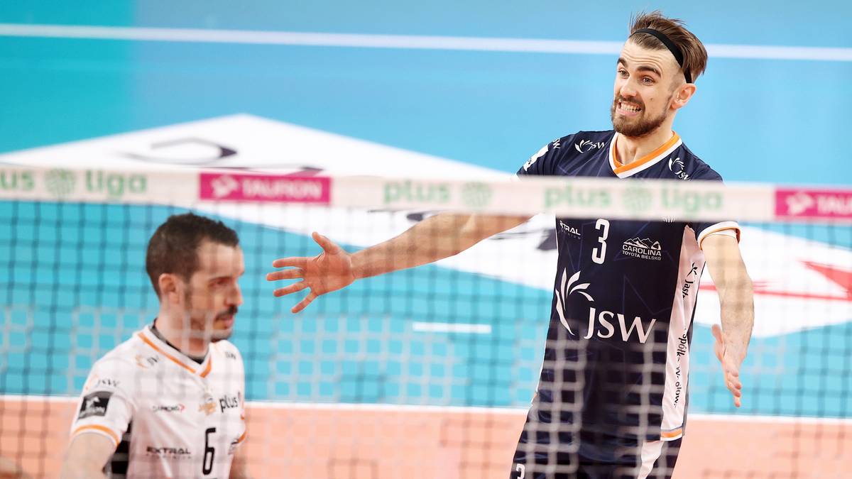 Dwóch siatkarzy na boisku, jeden z nich wykonuje gest ręką.